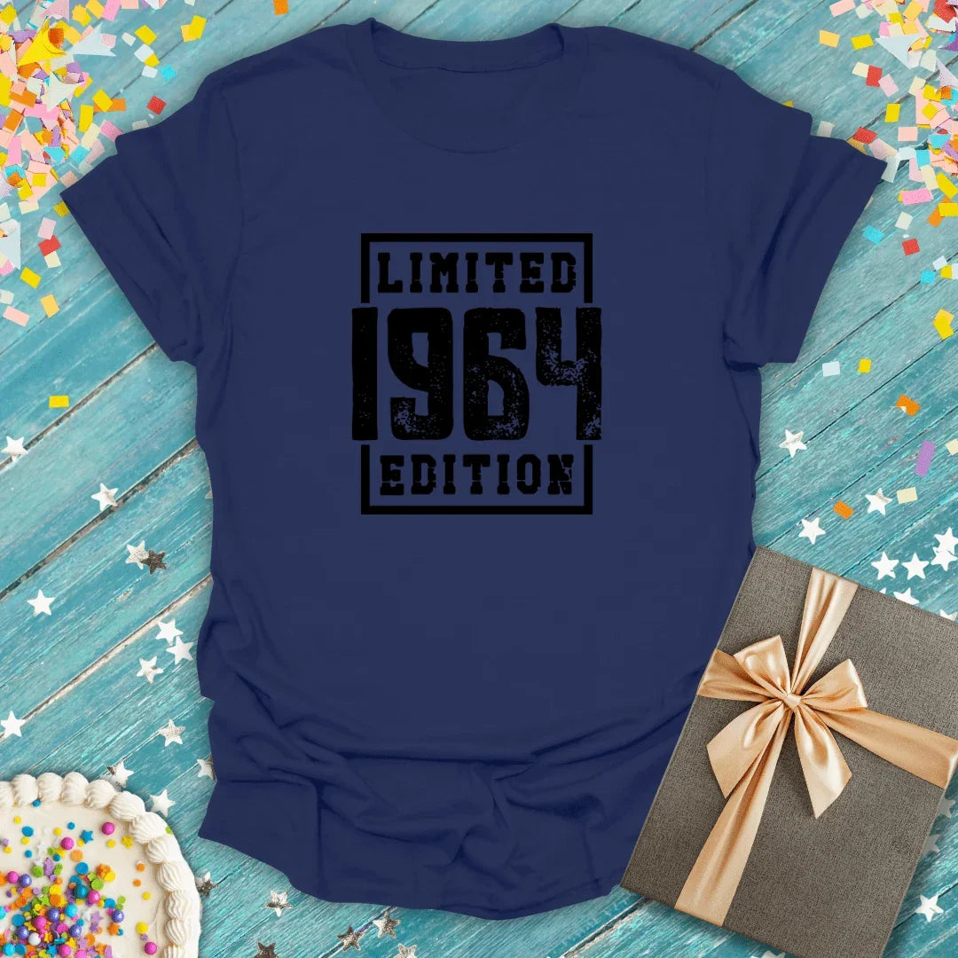 Navy blue 'Limited 1964 Edition' birthday tee with confetti, cake, and gift box on teal wood