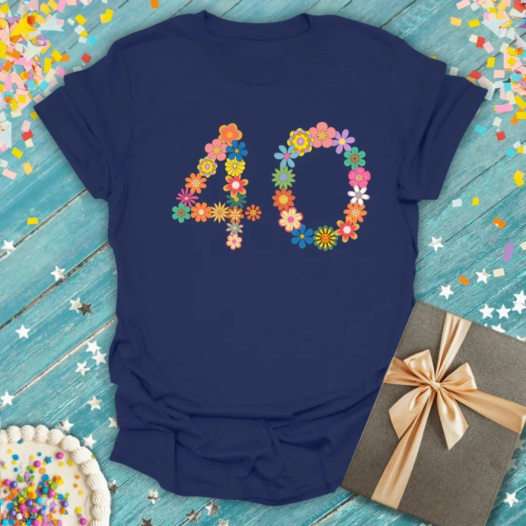 Navy blue 40th birthday tee with colorful floral number 40, gift box, and confetti on wood