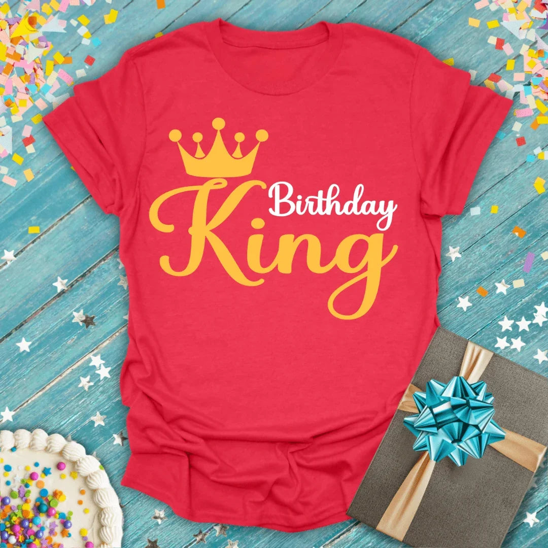 Red Birthday King t-shirt with crown graphic, gift box, and cake on confetti background