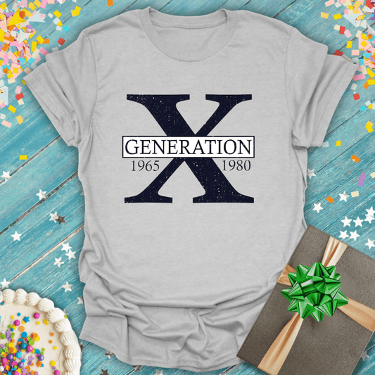Gray Generation X 1965-1980 tee with confetti, cake, and gift on blue wood background