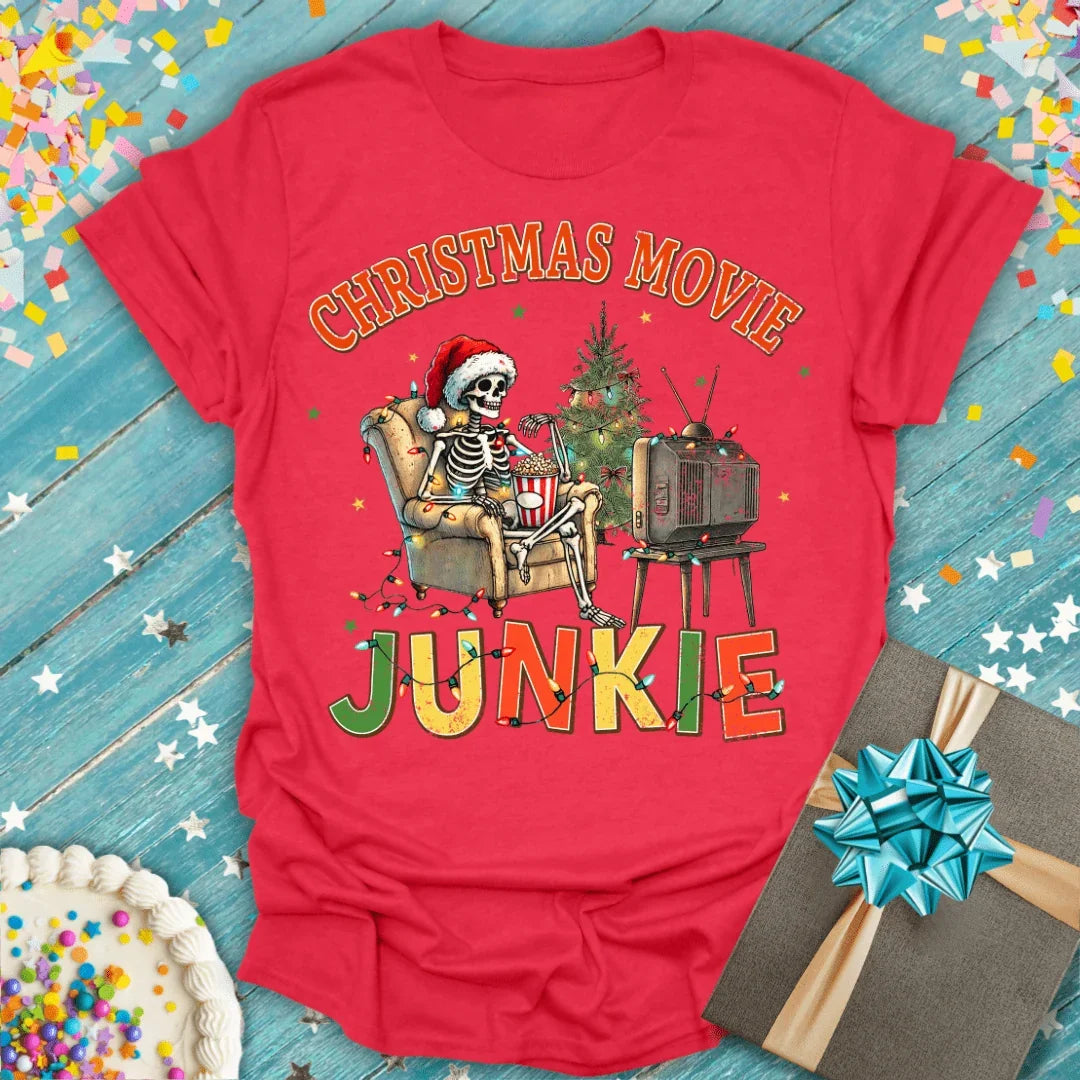 Red Christmas Movie Junkie tee with skeleton watching TV, holiday lights, and gift box