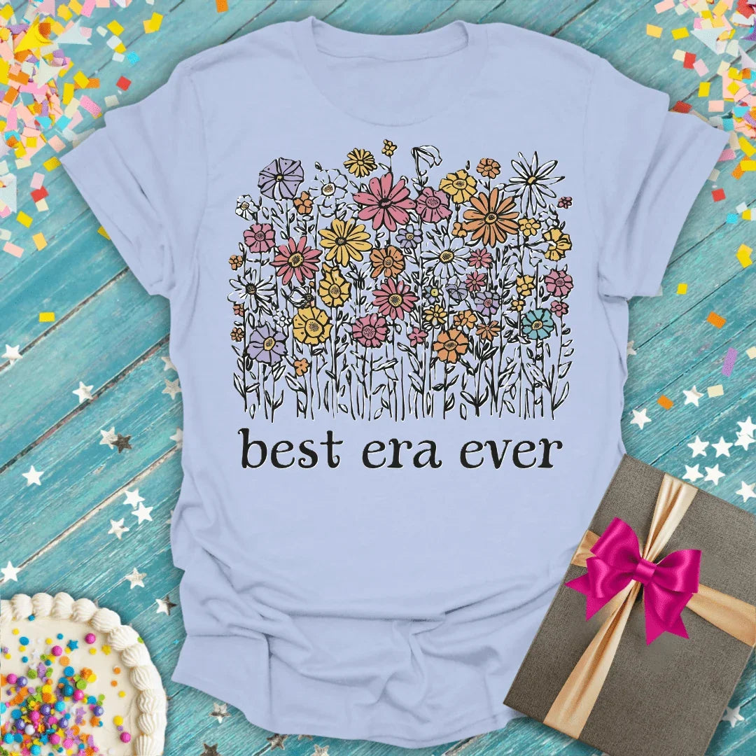 Light blue Epic Era Tees t-shirt featuring a colorful wildflower bouquet and 'best era ever' text.