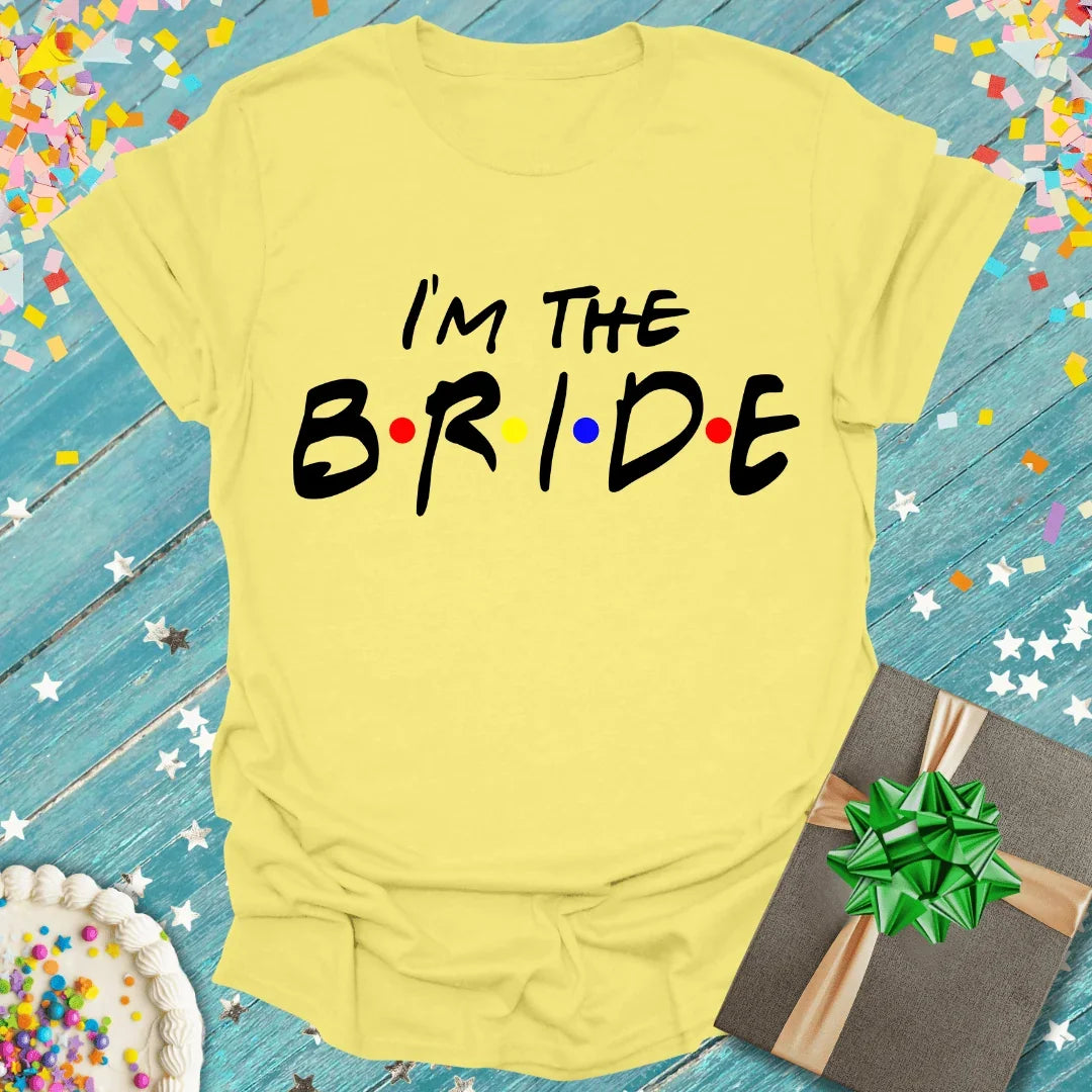 Yellow 'I'm The Bride' tee with colorful dots, gift box, and confetti for wedding celebrations