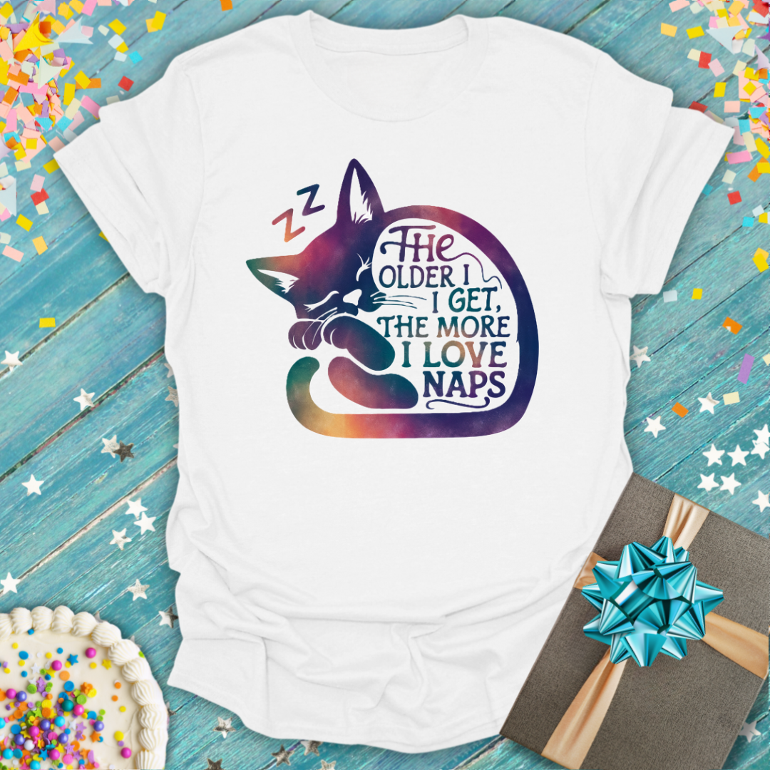 Epic Era Tees white t-shirt featuring a colorful sleeping cat graphic and 'The Older I Get, The More I Like Naps' text.