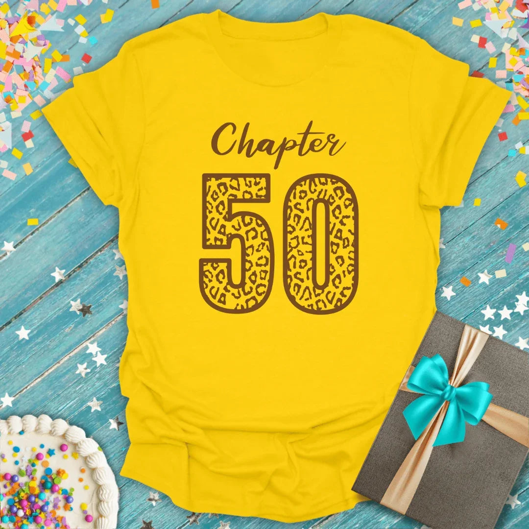 Yellow 'Chapter 50' leopard print birthday tee with confetti, cake, and gift