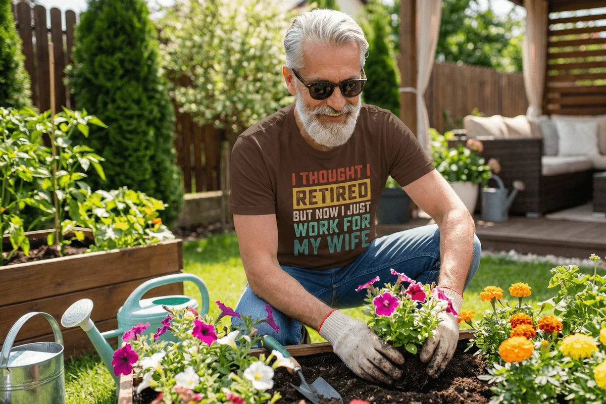 Man gardening in funny retired tee, planting flowers in backyard garden