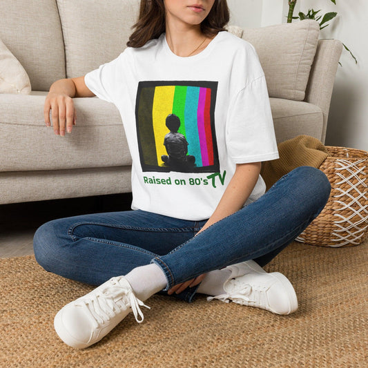 White 'Raised on 80's TV' tee by Epic Era Tees featuring retro test pattern graphic with child silhouette and green text.