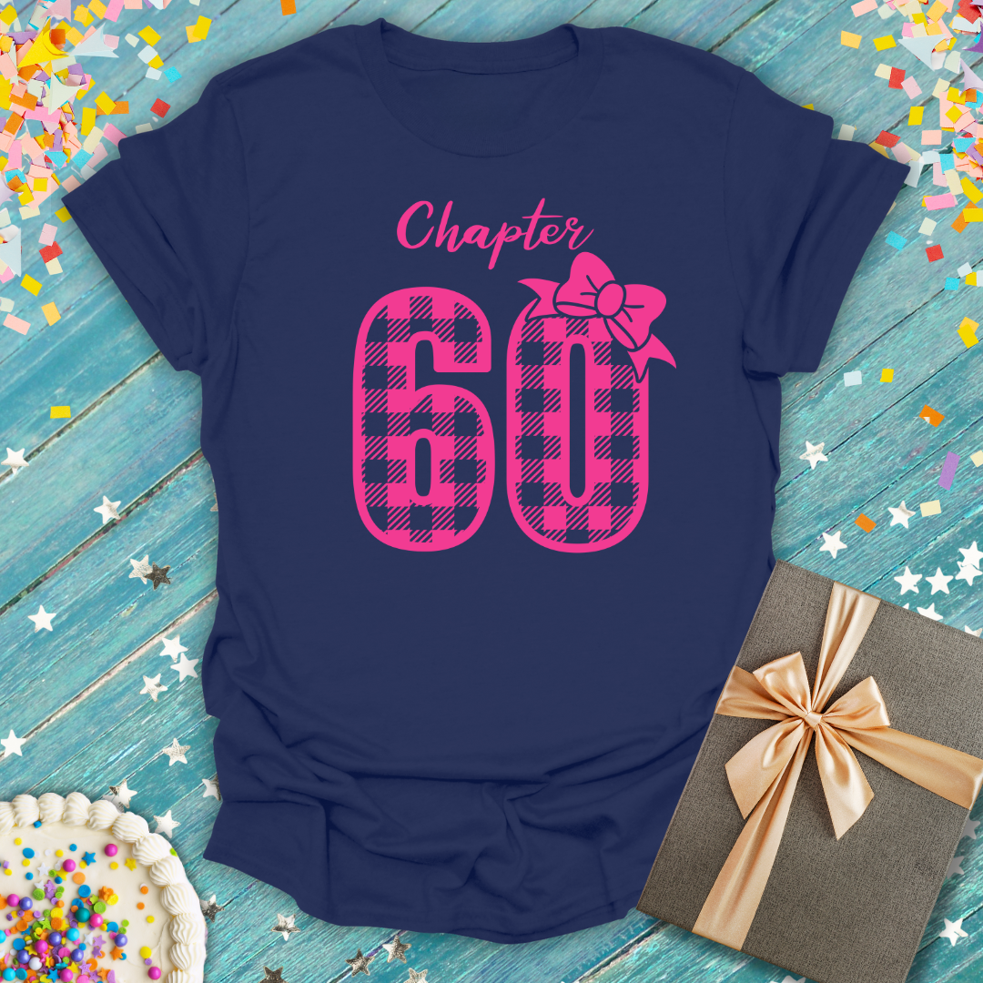 Navy blue Epic Era Tees t-shirt featuring a 'Chapter 60' design in pink buffalo check with a bow.