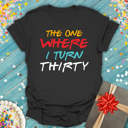Black birthday tee saying 'The One Where I Turn Thirty' with cake, gift, and confetti — perfect 30th birthday gift