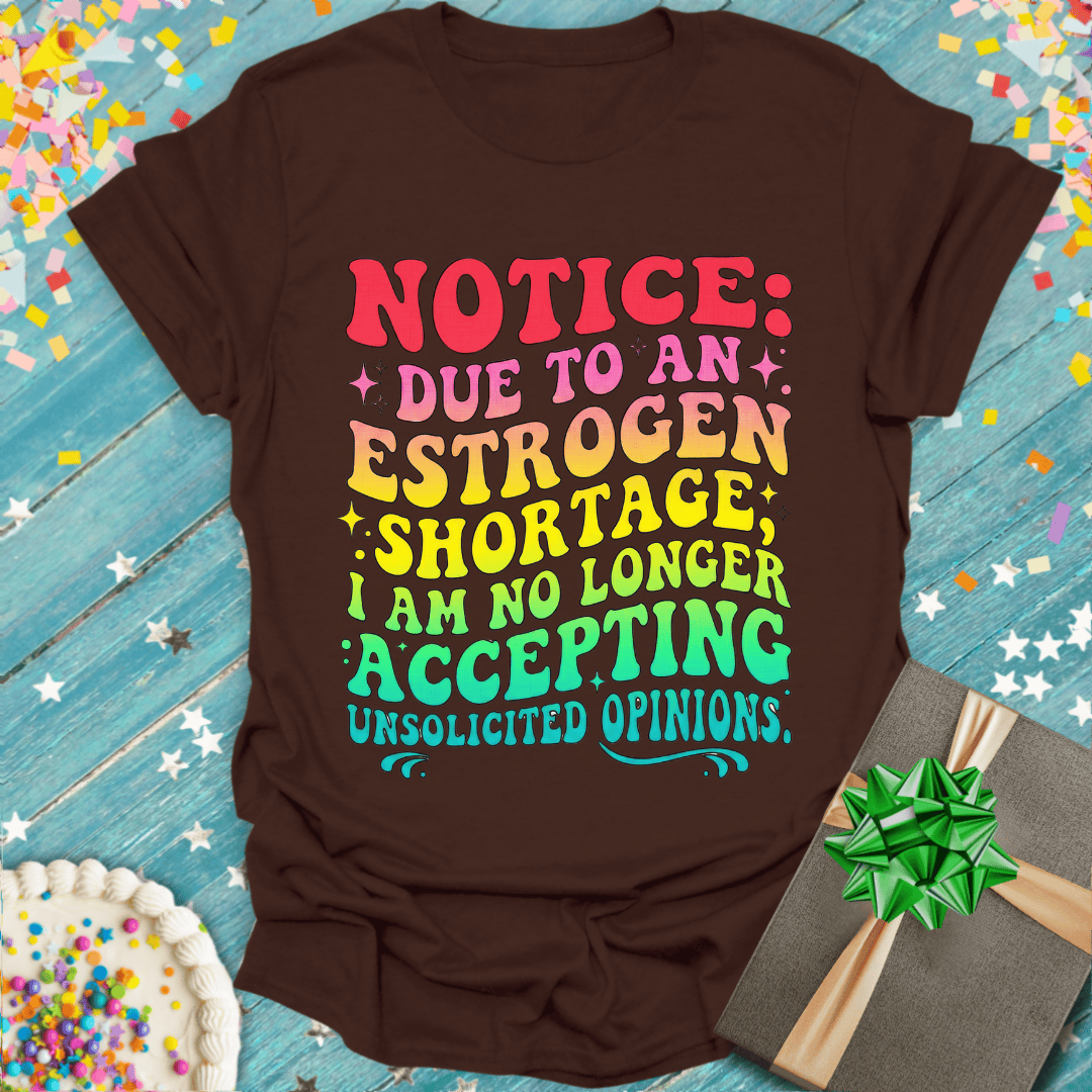 Brown graphic tee with colorful 'Estrogen Shortage' quote, birthday cake & gift box, soft women's shirt