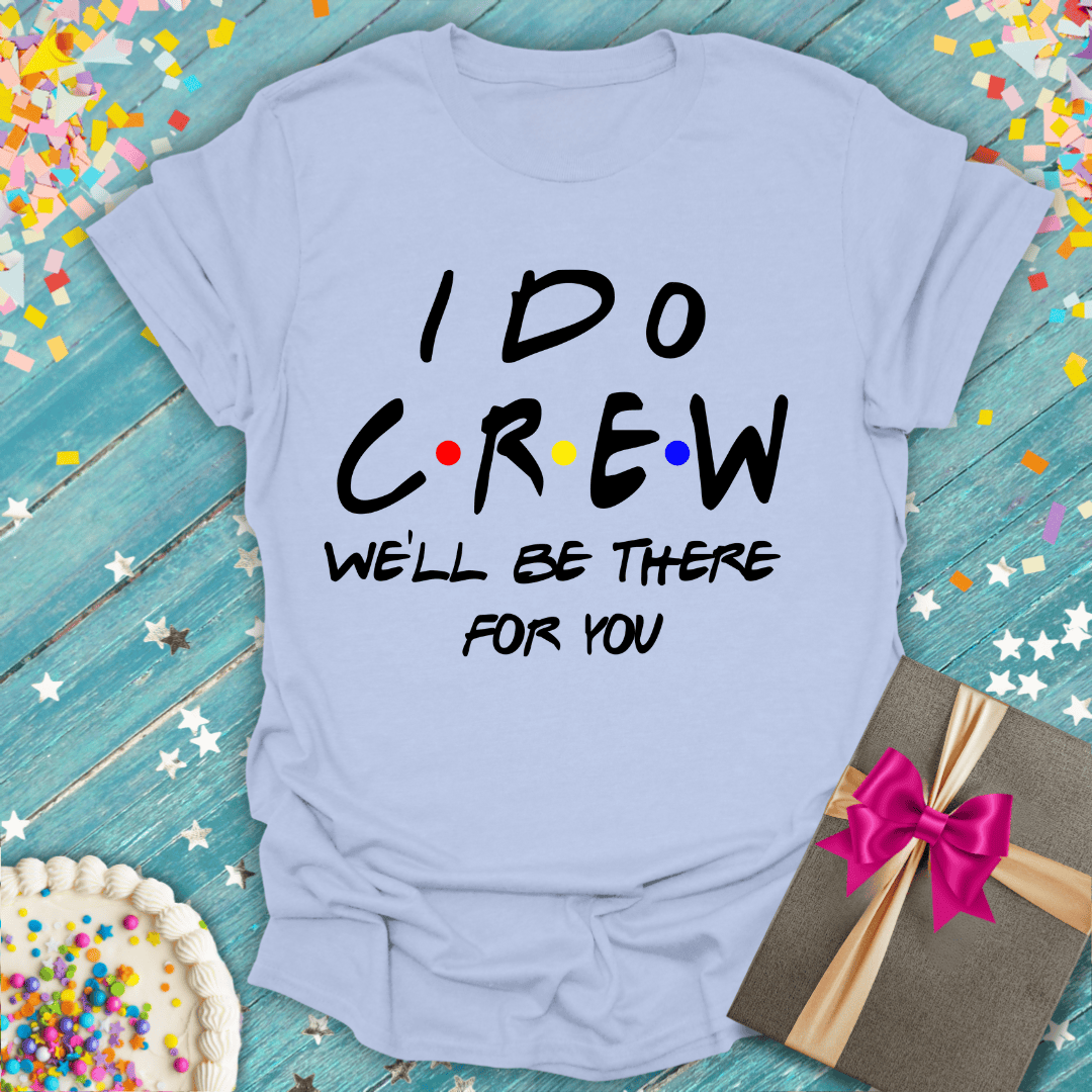 Light blue 'I Do Crew' tee with colorful dots, gift box, and cake on confetti background — perfect for wedding parties