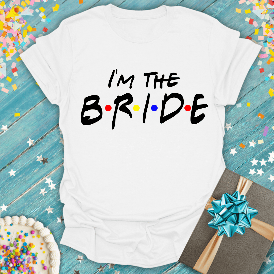 I'm the Bride t-shirt with colorful dots, on blue wood with confetti, cake, and gift—perfect for bridal parties