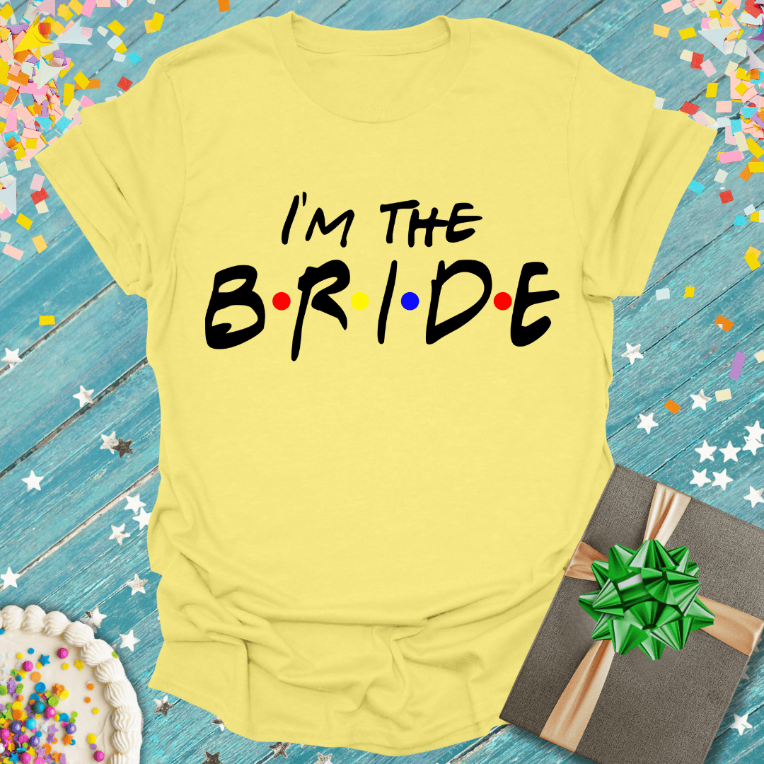 Yellow 'I'm The Bride' tee with colorful dots, gift box, and confetti for wedding celebrations