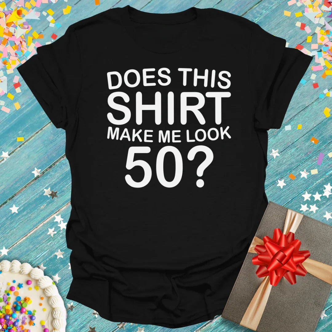 Black 50th birthday t-shirt with 'Does This Shirt Make Me Look 50?' text, gift box, and cake on confetti background