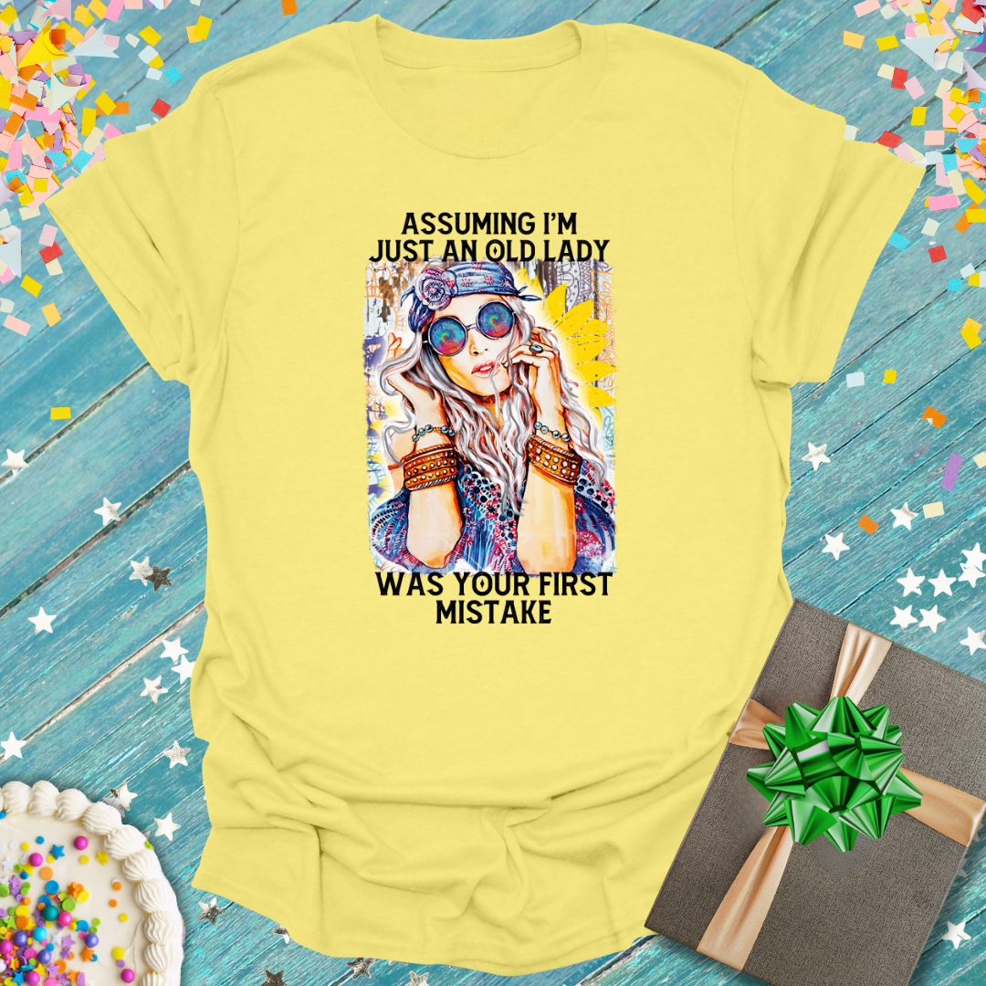 Yellow Epic Era Tees graphic tee featuring an artistic woman and 'Assuming I'm Just An Old Lady' text.