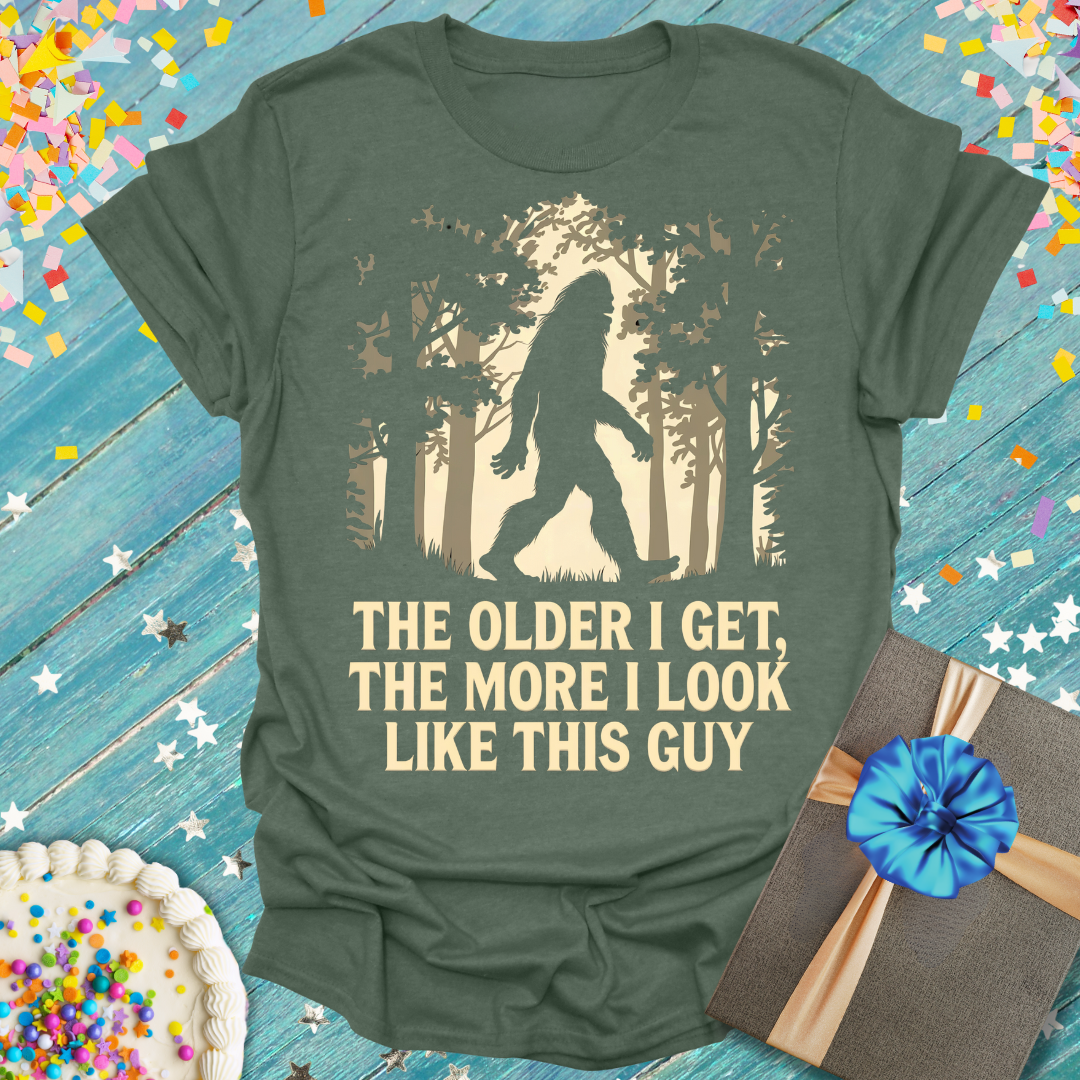 Epic Era Tees olive green shirt with a Bigfoot graphic and 'The Older I Get, The More I Look Like This Guy' text.