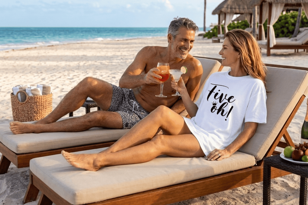 Woman wearing a white Epic Era Tees t-shirt with 'Five Oh!' in black cursive on a sunny beach.