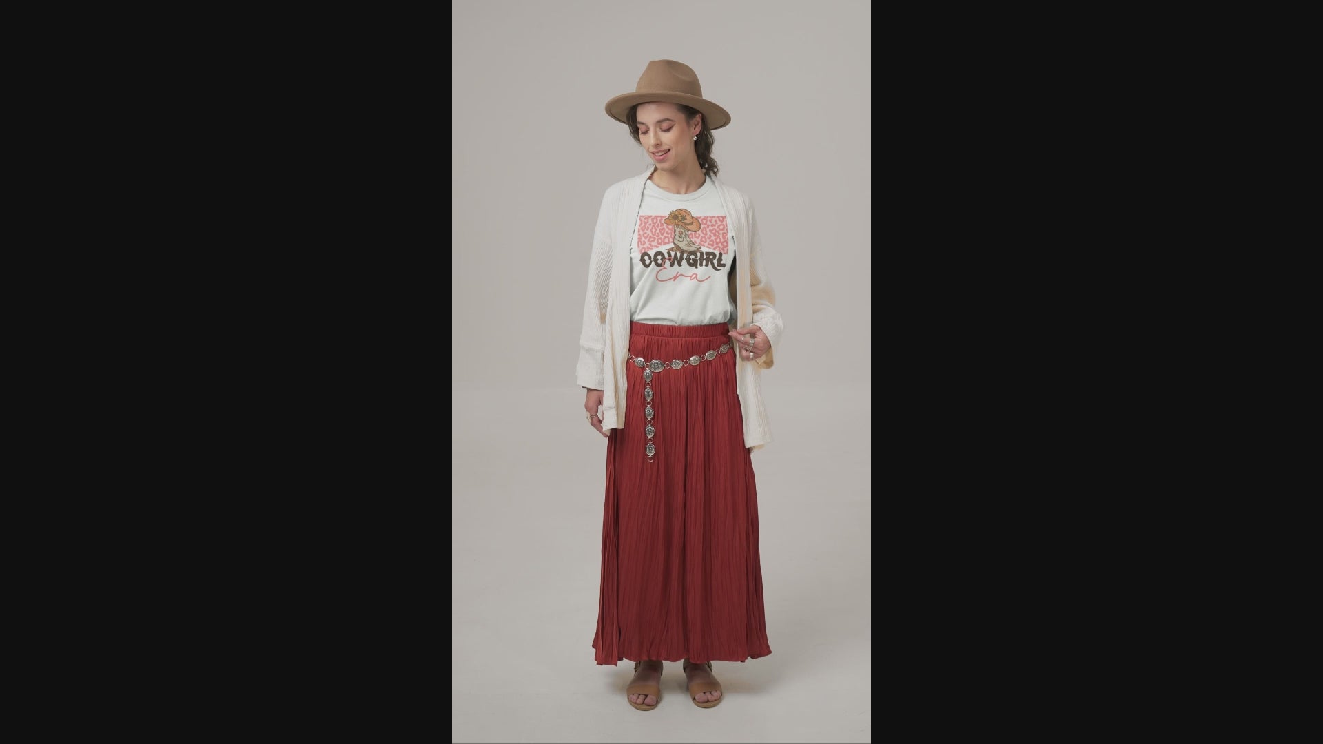 Woman in hat, long skirt with a Cowgirl Era t-shirt on